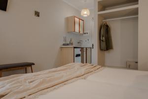 a white bedroom with a bed and a kitchen at Domus Alta in Tsilivi