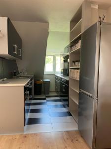 a kitchen with a stainless steel refrigerator and a floor at Apartman Na Bubnu in Náchod