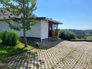 a house with a tree and a walkway at Apartman Na Bubnu in Náchod