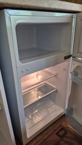 an empty refrigerator with its door open in a kitchen at Domek Samanta in Grzybina
