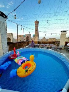 a swimming pool with a toy duck and a raft at Golden Minaret with Terrace in Bukhara