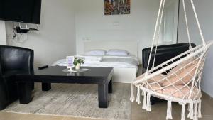 a room with a hammock and a table and a bed at Zimmer Monte in Dāliyat el Karmil +121 photos
