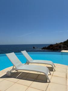 a white lounge chair sitting next to a swimming pool at Studio calme vue mer pieds dans l'eau in Saint-Raphaël