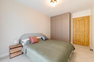 a bedroom with a bed and a wooden door at Navy Blue Apartment - SPA - Basen - Parking in Dziwnów +18 photos