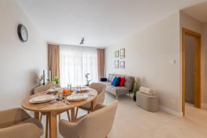 a dining room and living room with a table and chairs at Navy Blue Apartment - SPA - Basen - Parking in Dziwnów