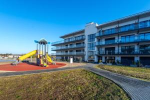 a playground in front of an apartment building at Navy Blue Apartment - SPA - Basen - Parking in Dziwnów