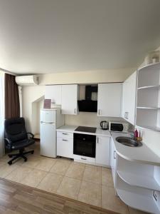 a kitchen with white cabinets and a sink and a chair at Smart House Home in Kyiv