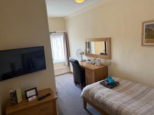 a hotel room with a bed and a desk and a television at White Horse Tavern in Telford