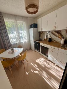 a kitchen with a table and a table and chairs at Lake&Forest&City in Riga