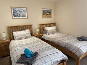 a bedroom with two beds and a blue towel on the bed at White Horse Tavern in Telford