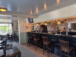 a bar in a restaurant with chairs and tables at White Horse Tavern in Telford