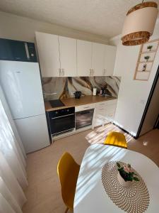 a kitchen with white cabinets and a table and a table and chairs at Lake&Forest&City in Riga