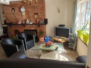 a living room with black chairs and a fireplace at Heathrow Ensuite in West Drayton