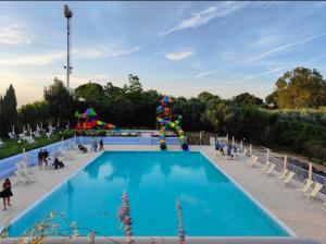 a large swimming pool with a water park at Le Giuggiole in Tuscany in Usigliano