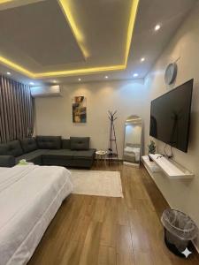 a living room with a large bed and a large flat screen tv at قنوف-شقة فندقية خاصة ذ in Abha
