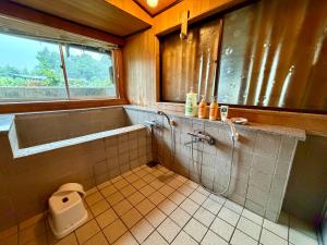 a bathroom with a tub and a toilet in it at 未来のふるさと村 in Yamaguchi +25 photos