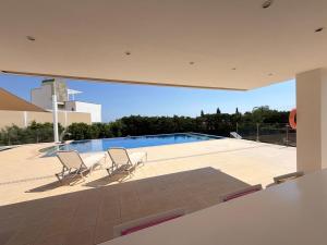 two chairs and a swimming pool in a house at The Sea Breeze in Paralimni
