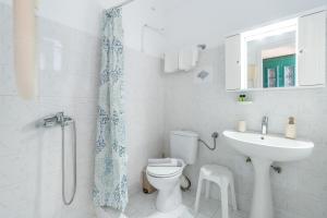 a white bathroom with a toilet and a sink at Synodinos Studios in Lixouri +95 photos