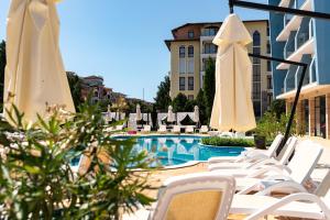 a group of chairs and umbrellas next to a pool at Hotel Pautalia in Sunny Beach