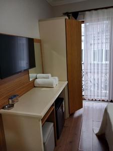 a hotel room with a desk with a flat screen tv at Çelik Crown Hotel in Trabzon