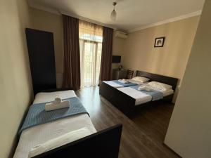 a hotel room with two beds and a window at Hotel Sunny Coast in Kobuleti