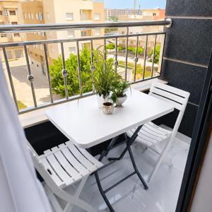 a white table and two chairs on a balcony at Nador Skyline Al Matar in Nador