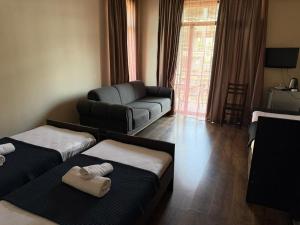a living room with two beds and a couch at Hotel Sunny Coast in Kobuleti