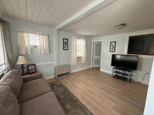 a living room with a couch and a flat screen tv at Crosswinds Motel in Old Orchard Beach