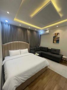 a bedroom with a large bed and a couch at قنوف-شقة فندقية خاصة ذ in Abha