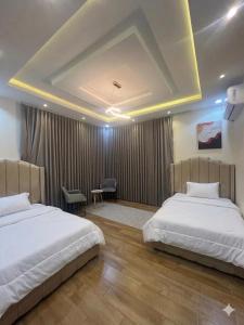 a hotel room with two beds and a desk at قنوف-شقة فندقية خاصة ذ in Abha
