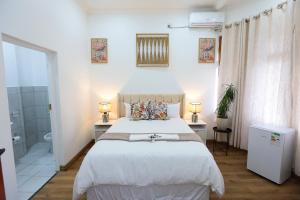 a bedroom with a large bed and a bathroom at Ferry Palms Guest Lodge in Arcadia +73 photos