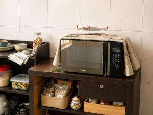a microwave on a table in a kitchen at One Private Room Near Dhaka Airport in Dhaka