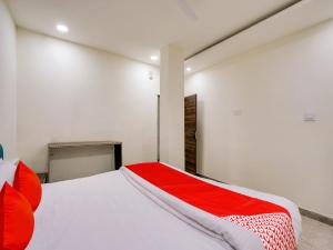 a bedroom with a large white bed with red pillows at HOTEL O M J HEIGHTS in Garhā