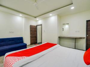 a bedroom with a large bed and a blue couch at HOTEL O M J HEIGHTS in Garhā