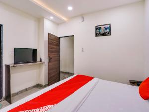 a bedroom with a bed and a tv on the wall at HOTEL O M J HEIGHTS in Garhā