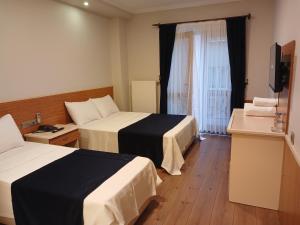 a hotel room with two beds and a television at Çelik Crown Hotel in Trabzon