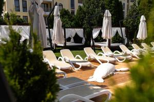 a row of chairs and umbrellas on a patio at Hotel Pautalia in Sunny Beach