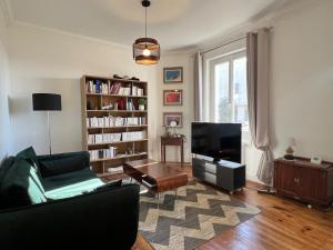 a living room with a couch and a tv at villa des roses in Bergerac