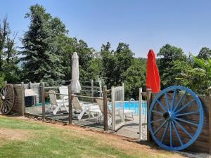 a fence with chairs and umbrellas next to a pool at maison infini in Les Salles-Lavauguyon