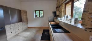 a large kitchen with a sink and a window at maison infini in Les Salles-Lavauguyon