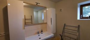 a bathroom with a white sink and a mirror at maison infini in Les Salles-Lavauguyon