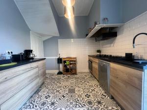 a kitchen with a counter and a tile floor at villa des roses in Bergerac
