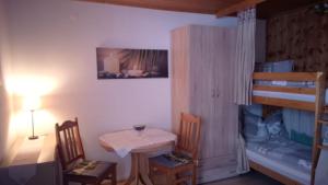 a small table and chairs in a room with a bunk bed at Fewo-Mirnig in Hochrindl