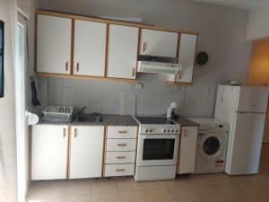 a kitchen with white cabinets and a white refrigerator at Velvet in Perea