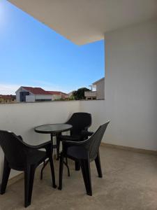 a table and chairs in a room with a window at ANTODO Batista in Novalja