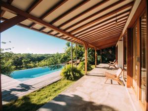 an outdoor patio with a view of a swimming pool at Villa YAMI Uluwatu Private Infinity Pool Jungle Views in Ungasan