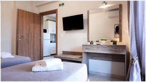 a room with two beds and a fireplace with a mirror at Buena Vista - San Mames in Agios Mamas