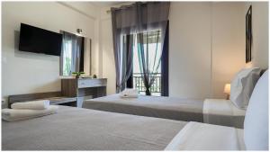 a hotel room with two beds and a window at Buena Vista - San Mames in Agios Mamas