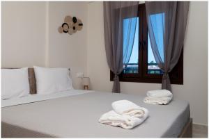 a bedroom with a bed with towels on it at Buena Vista - San Mames in Agios Mamas +20 photos