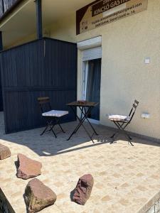 a patio with rocks and two chairs and a table at Kincső Vendégház Siófok in Siófok